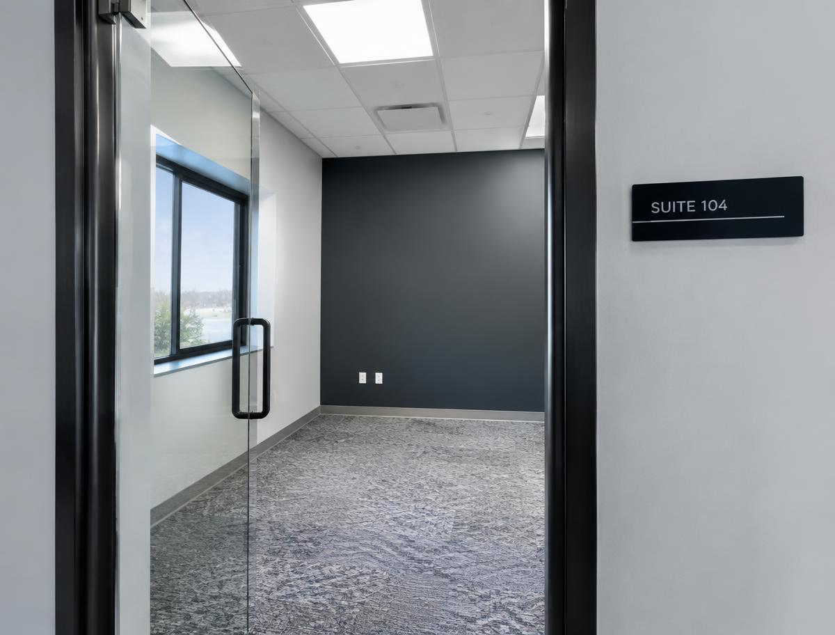 Freshly painted small commercial office suite with a dark accent wall and glass entry door